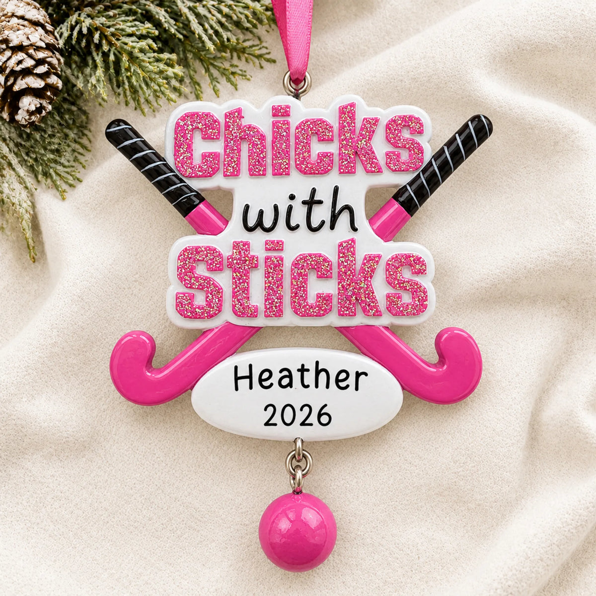 Personalized field hockey christmas ornament laid on a soft white knit blanket