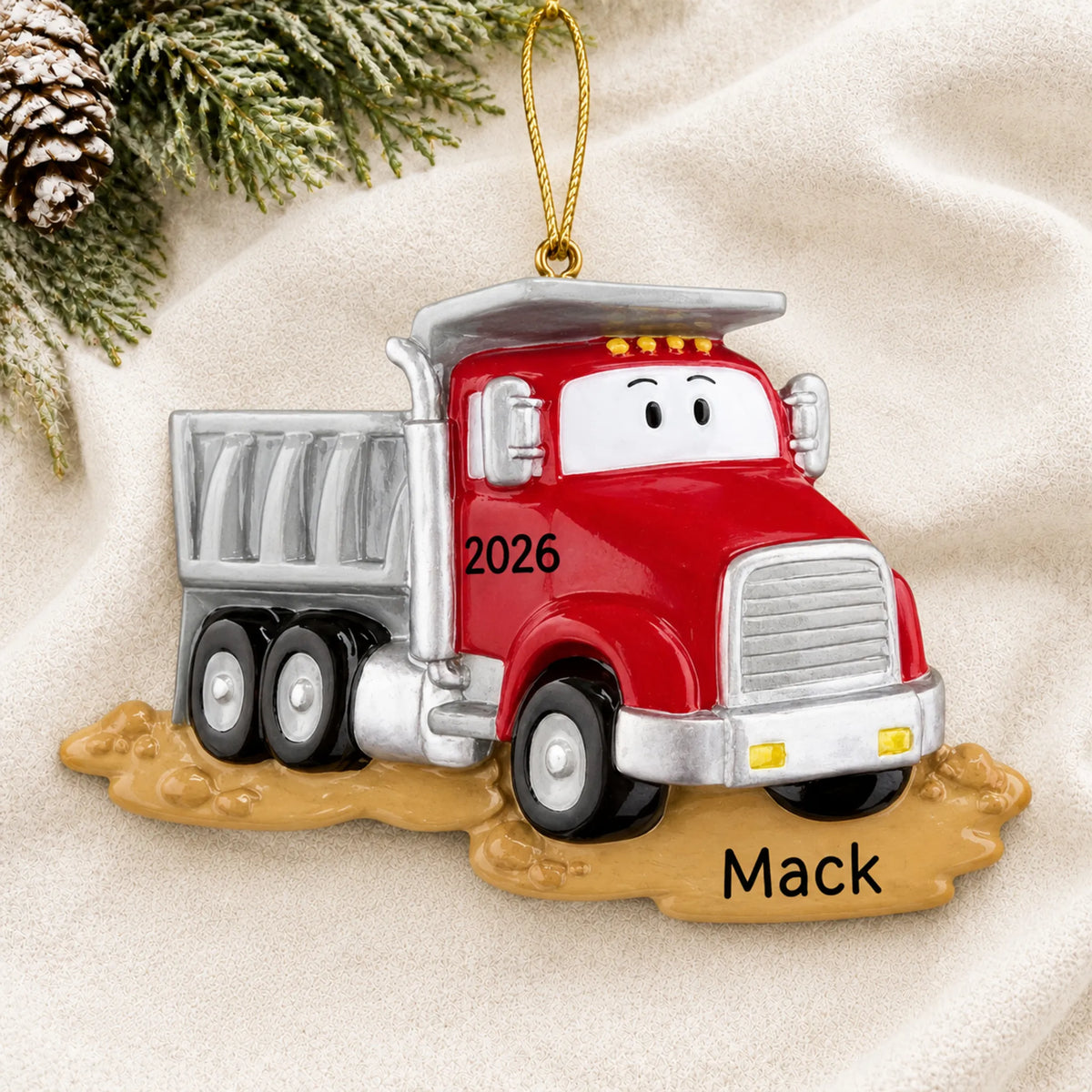 Personalized construction dump truck christmas ornament laid on a soft white knit blanket