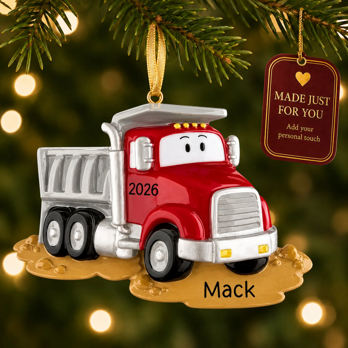 Construction dump truck christmas ornament hanging on a lit Christmas tree with a Made Just For You gift tag