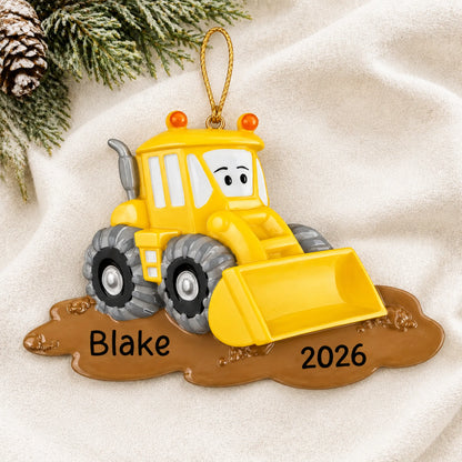 Personalized bulldozer christmas ornament laid on a soft white knit blanket