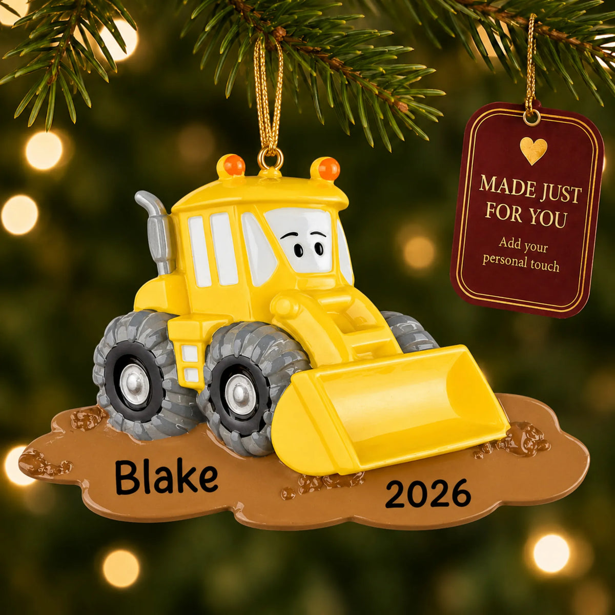 Bulldozer christmas ornament hanging on a lit Christmas tree with a Made Just For You gift tag