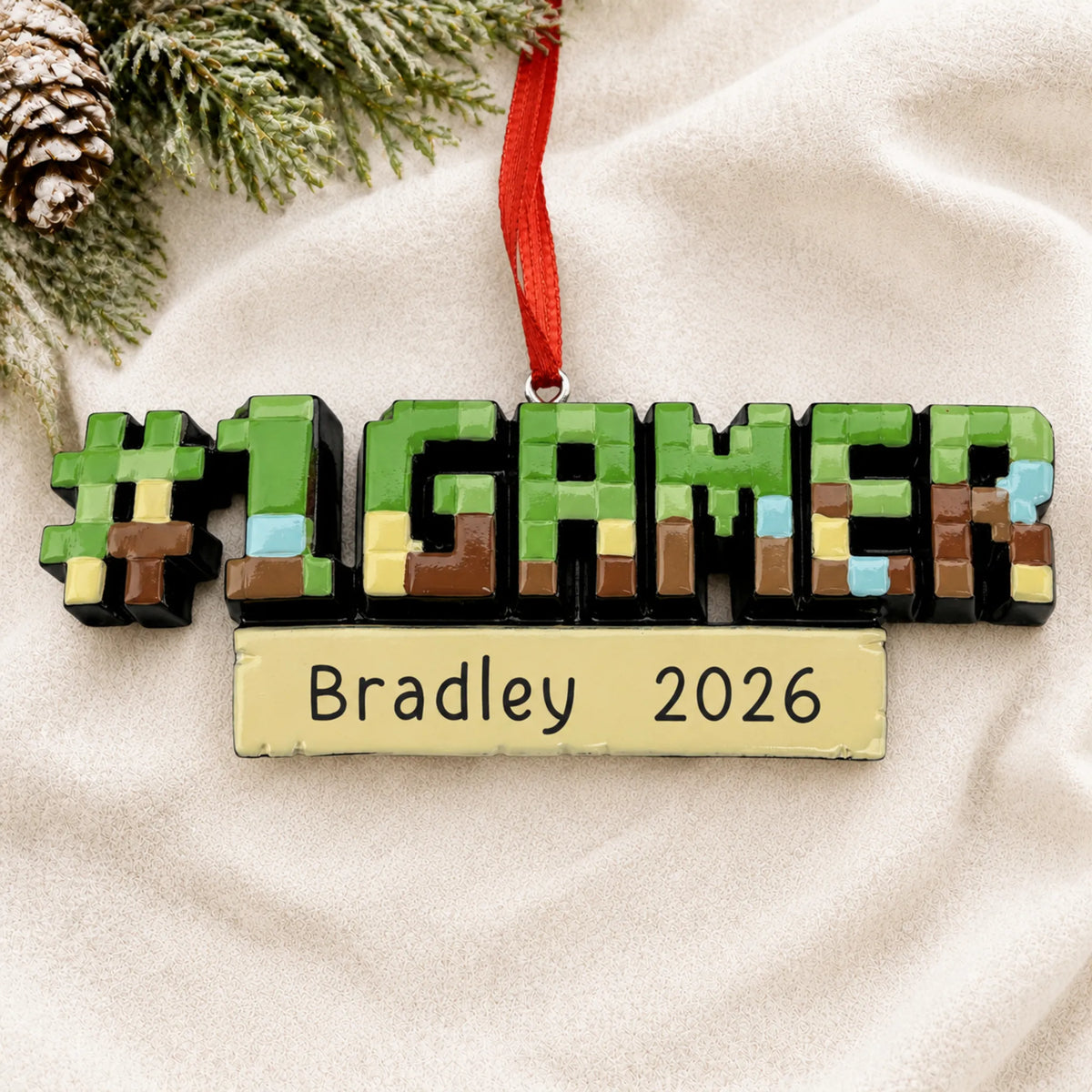 Personalized pixel block gamer christmas ornament laid on a soft white knit blanket