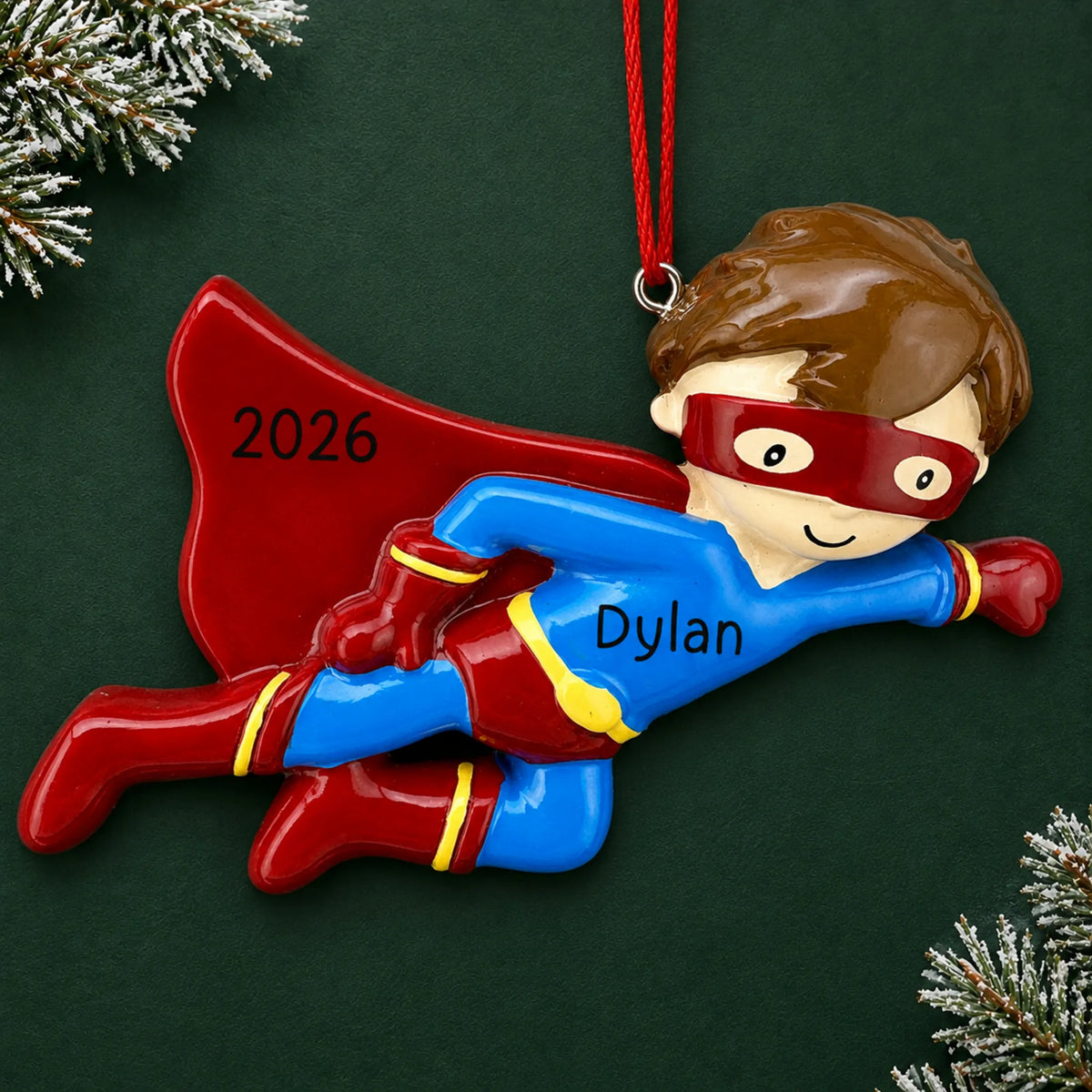 Personalized super hero christmas ornament on a dark green pine background