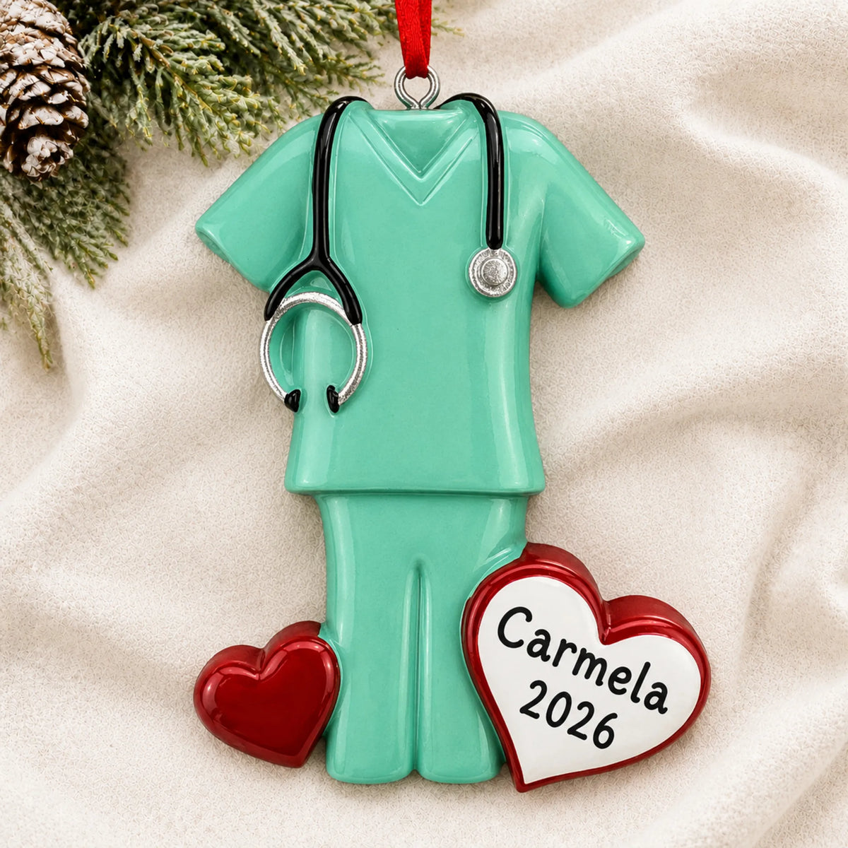 Personalized green scrubs christmas ornament laid on a soft white knit blanket