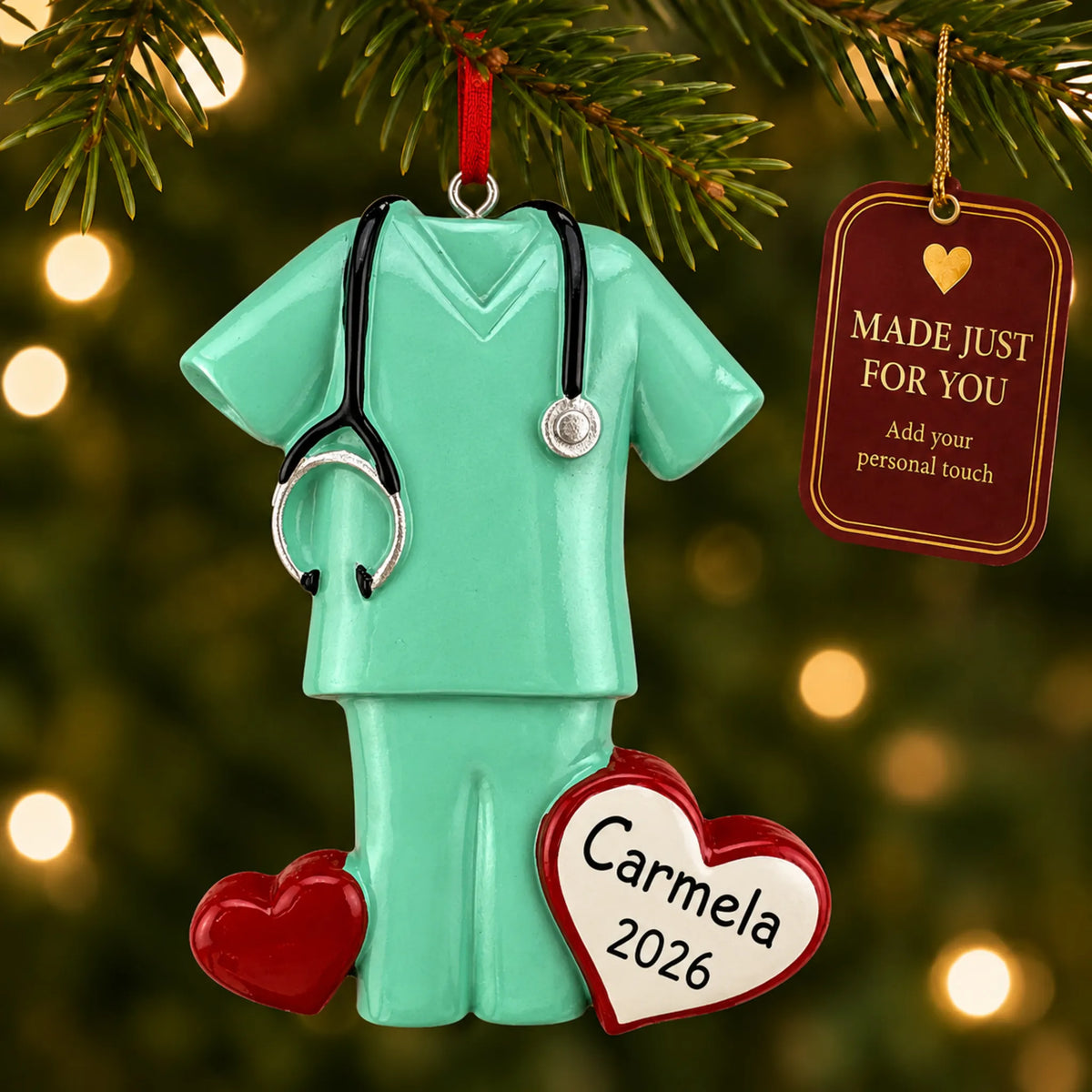 Green scrubs christmas ornament hanging on a lit Christmas tree with a Made Just For You gift tag