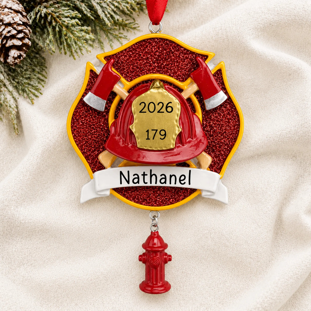 Personalized firefighter emblem christmas ornament laid on a soft white knit blanket