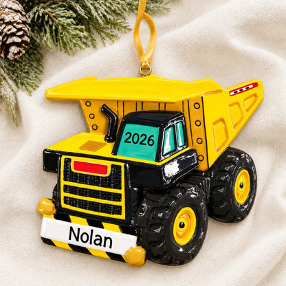Personalized dump truck xl christmas ornament laid on a soft white knit blanket