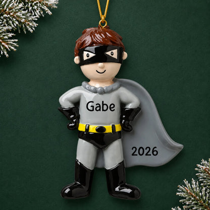 Personalized caped super hero christmas ornament on a dark green pine background