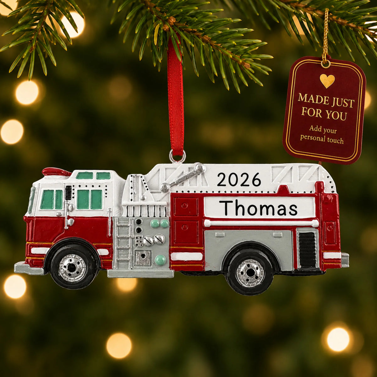 Firetruck christmas ornament hanging on a lit Christmas tree with a Made Just For You gift tag