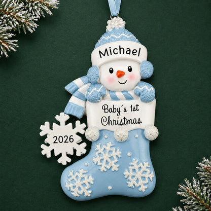 Personalized blue snowman baby's 1st christmas ornament on a dark green pine background