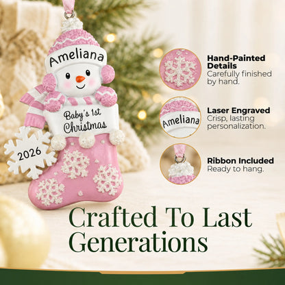 Hand-painted details and laser engraved personalization on the pink snowman baby's 1st christmas ornament, ribbon included