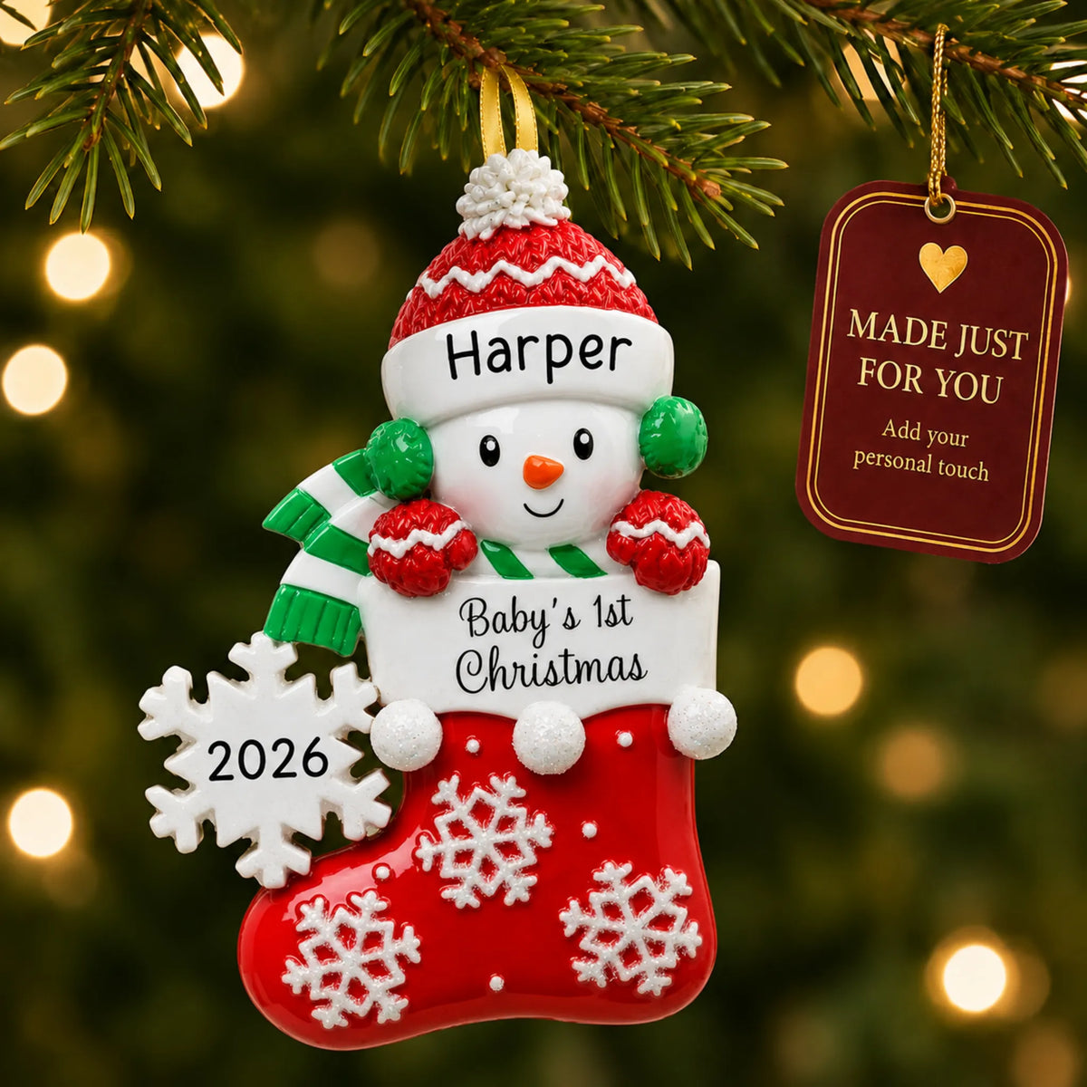 Red snowman baby's 1st christmas ornament hanging on a lit Christmas tree with a Made Just For You gift tag