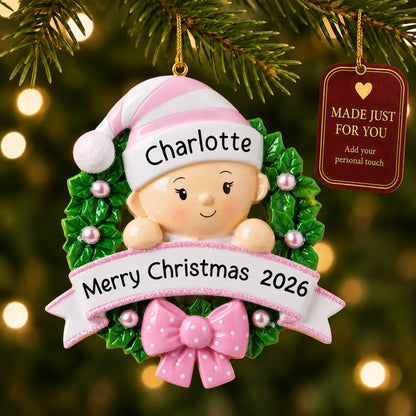 Pink baby girl wreath christmas ornament hanging on a lit Christmas tree with a Made Just For You gift tag