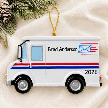 Personalized postal worker mail truck christmas ornament laid on a soft white knit blanket