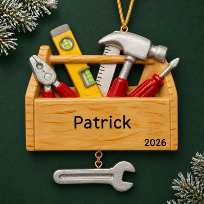 Personalized handyman tool box christmas ornament on a dark green pine background