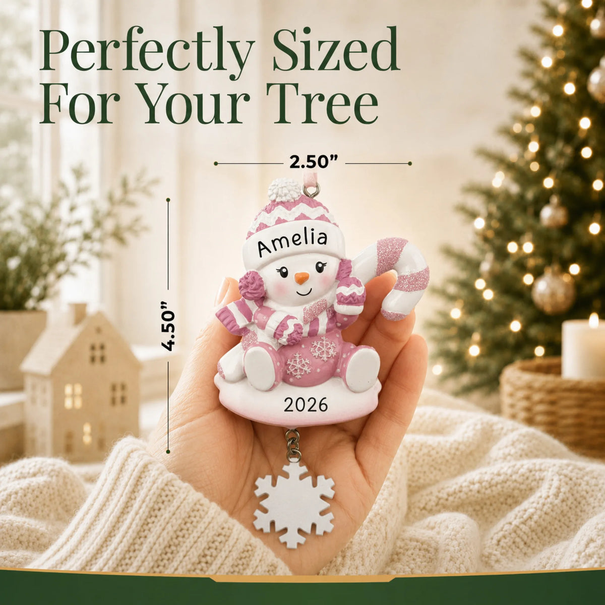 Size guide: the personalized baby girl snowman christmas ornament shown in hand next to a Christmas tree
