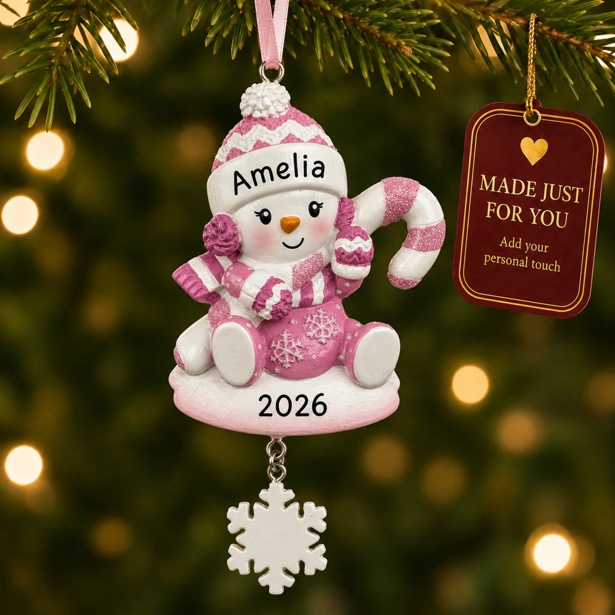 Baby girl snowman christmas ornament hanging on a lit Christmas tree with a Made Just For You gift tag