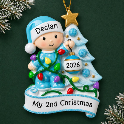 Personalized blue baby's 2nd christmas ornament on a dark green pine background