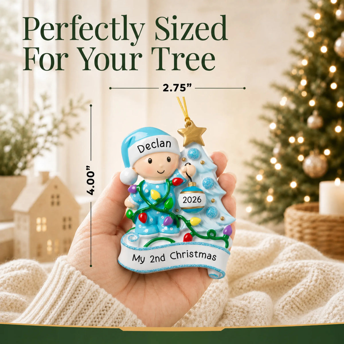 Size guide: the personalized blue baby's 2nd christmas ornament is 2.75 in wide by 4.00 in tall, shown in hand