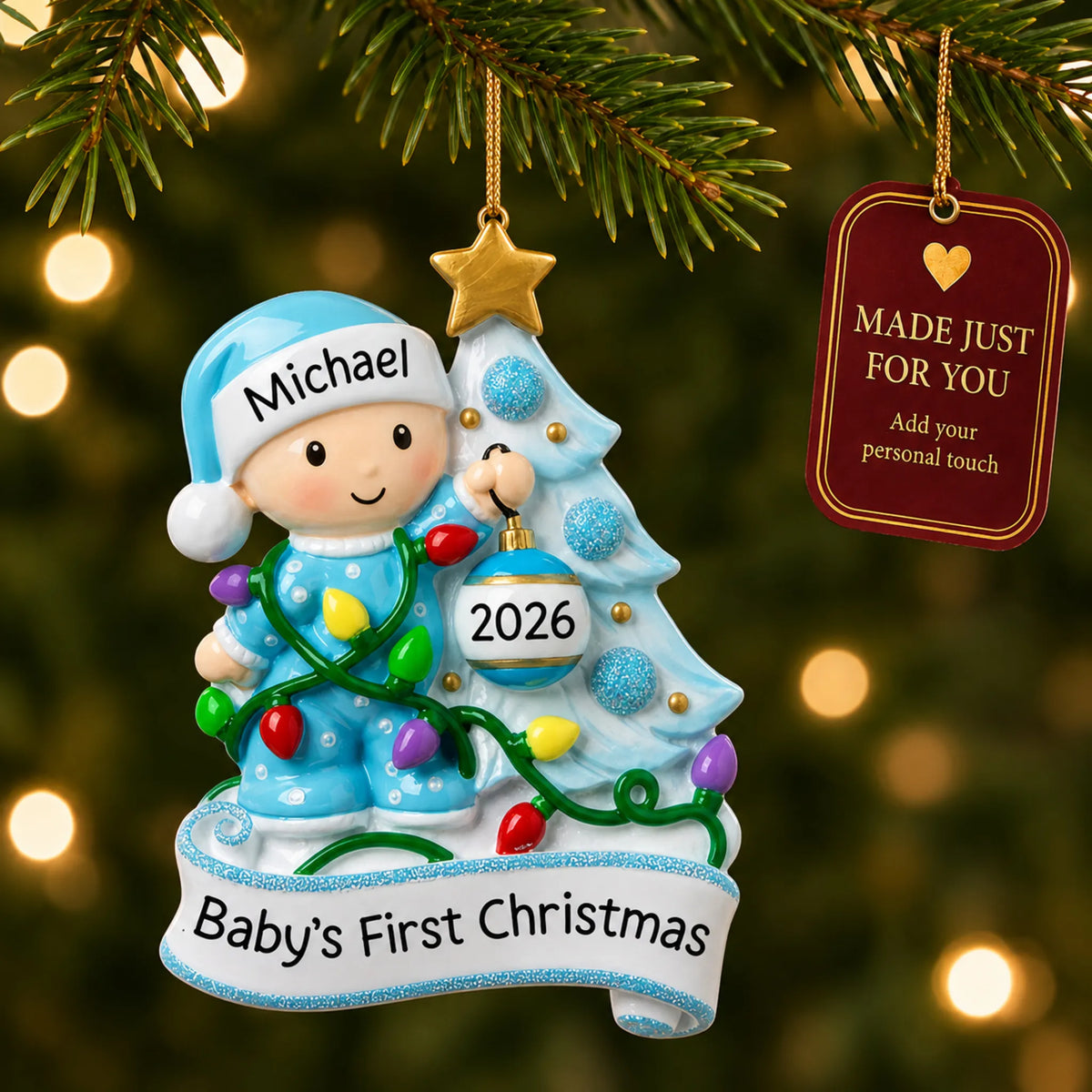 Blue baby's 1st christmas tree ornament hanging on a lit Christmas tree with a Made Just For You gift tag