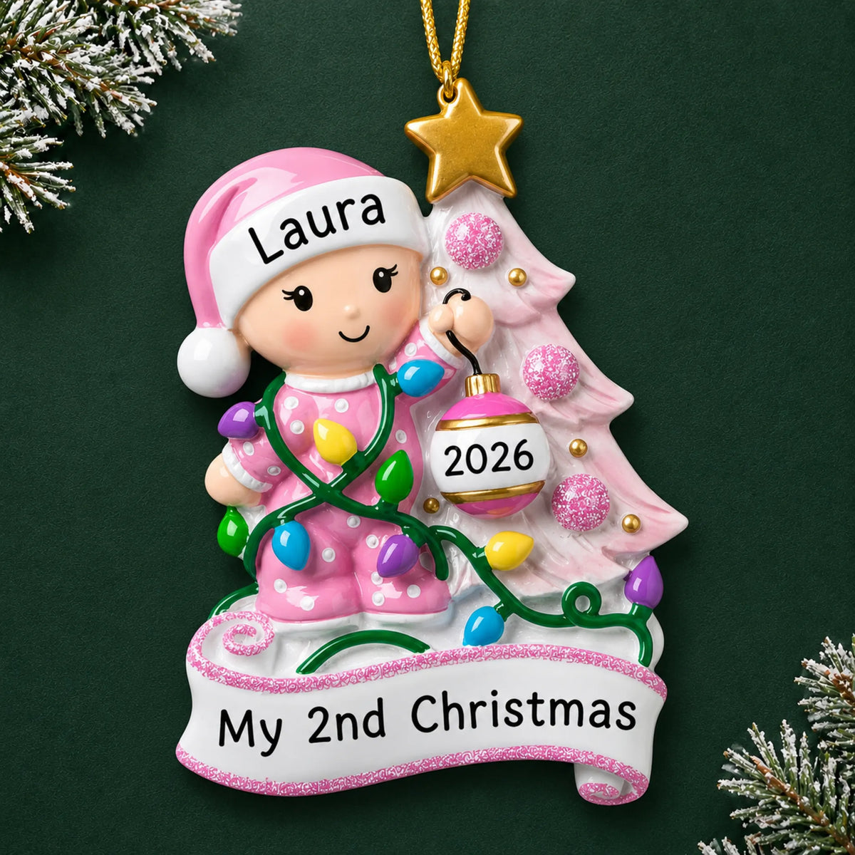 Personalized pink baby's 2nd christmas ornament on a dark green pine background