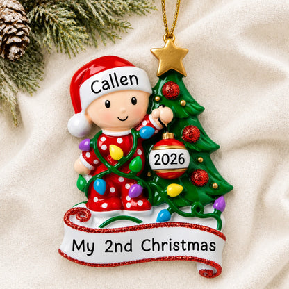 Personalized red baby's 2nd christmas ornament laid on a soft white knit blanket