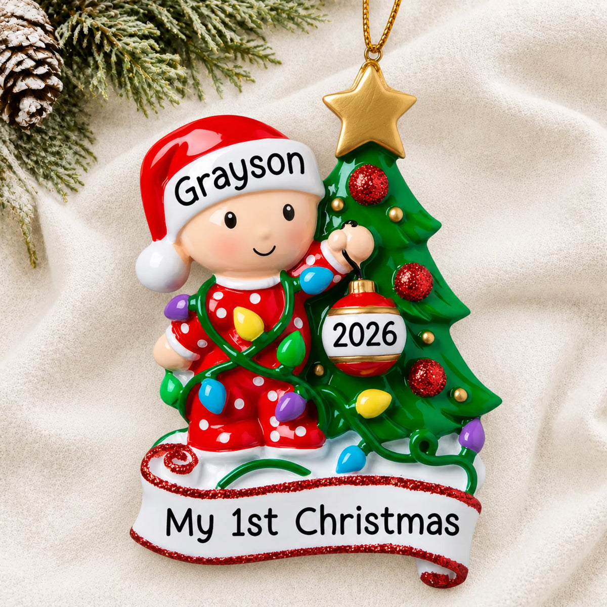 Personalized red baby's 1st christmas tree ornament laid on a soft white knit blanket