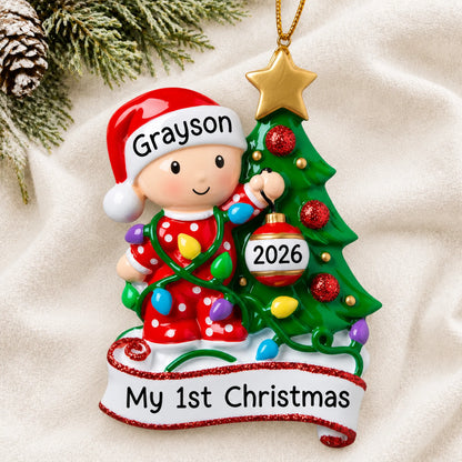 Personalized red baby's 1st christmas tree ornament laid on a soft white knit blanket