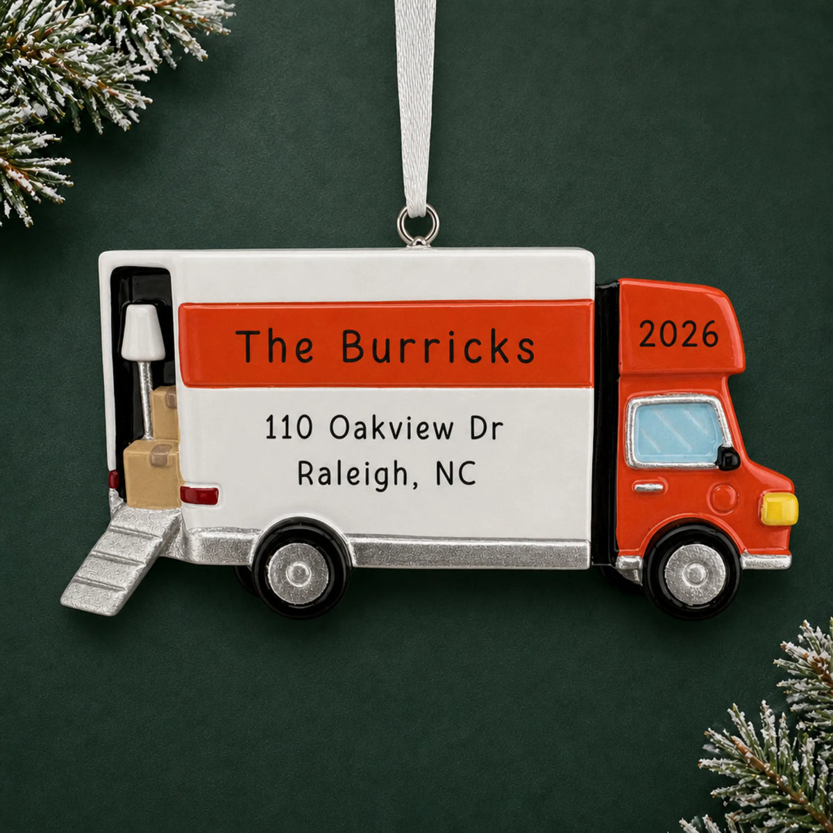 Personalized Moving Truck christmas ornament on a dark green pine background