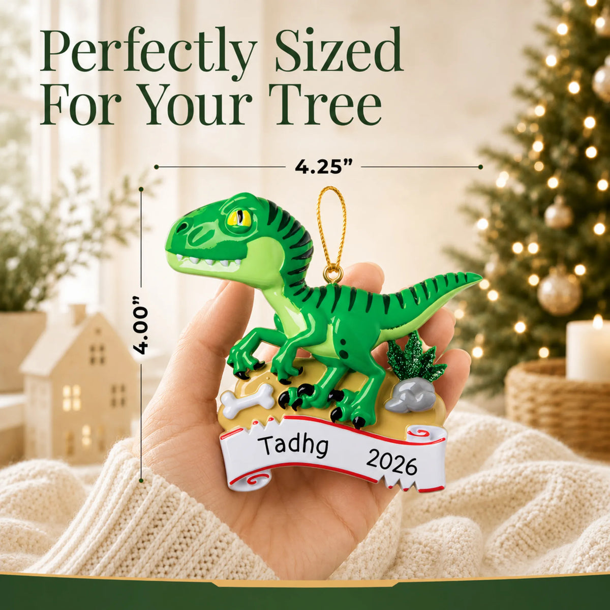 Size guide: the personalized green t-rex christmas ornament is 4.25 in wide by 4.00 in tall, shown in hand