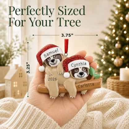 Size guide: the personalized sloth couple christmas ornament is 3.75 in wide by 3.25 in tall, shown in hand