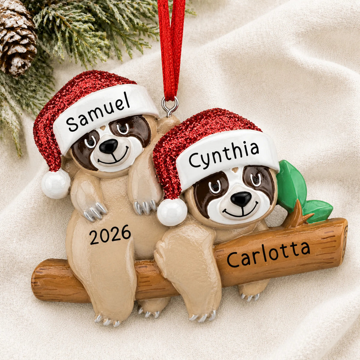 Personalized sloth couple christmas ornament laid on a soft white knit blanket