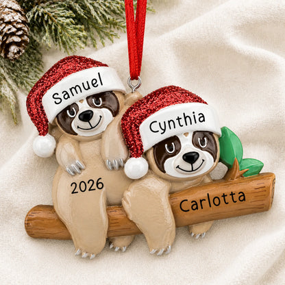 Personalized sloth couple christmas ornament laid on a soft white knit blanket