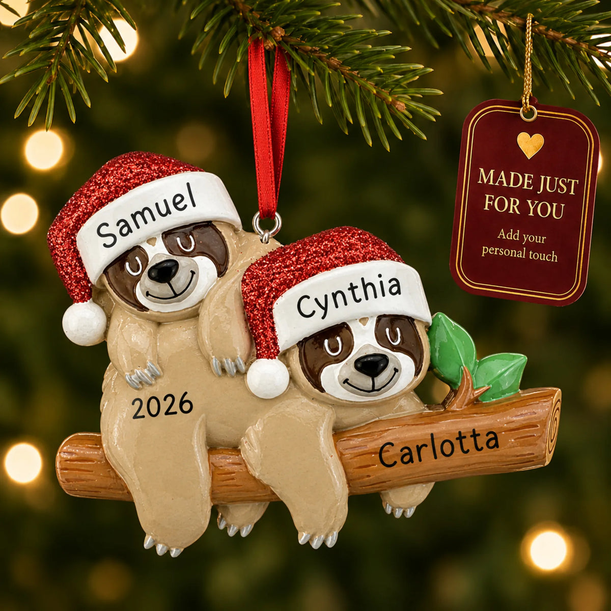 Sloth couple christmas ornament hanging on a lit Christmas tree with a Made Just For You gift tag