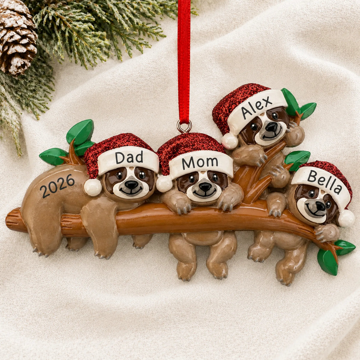 Personalized sloth family of 4 christmas ornament laid on a soft white knit blanket