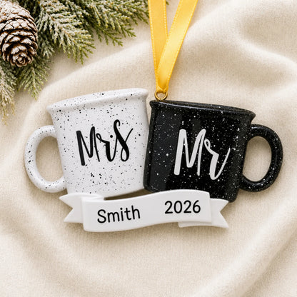 Personalized Mr & Mrs couple mug Christmas ornament on a cream knit blanket beside pine and pinecones