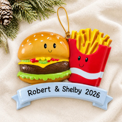 Personalized Burger & Fries Couple christmas ornament laid on a soft white knit blanket