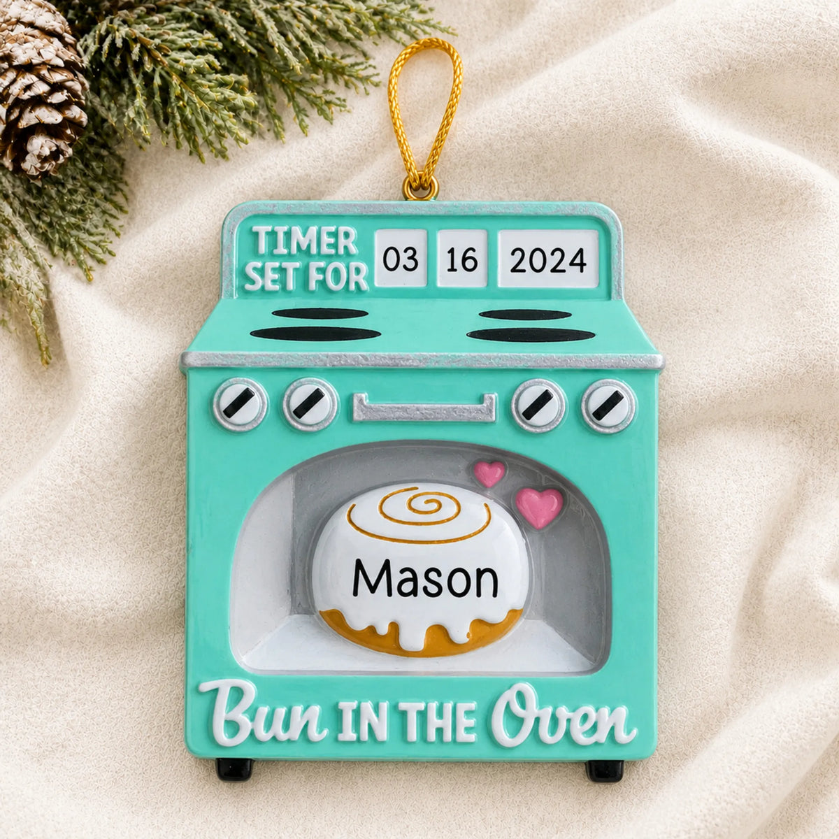 Personalized Bun In The Oven christmas ornament laid on a soft white knit blanket