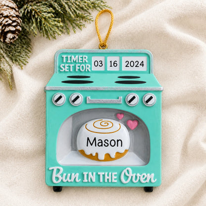 Personalized Bun In The Oven christmas ornament laid on a soft white knit blanket
