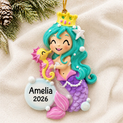 Personalized mermaid girl christmas ornament laid on a soft white knit blanket