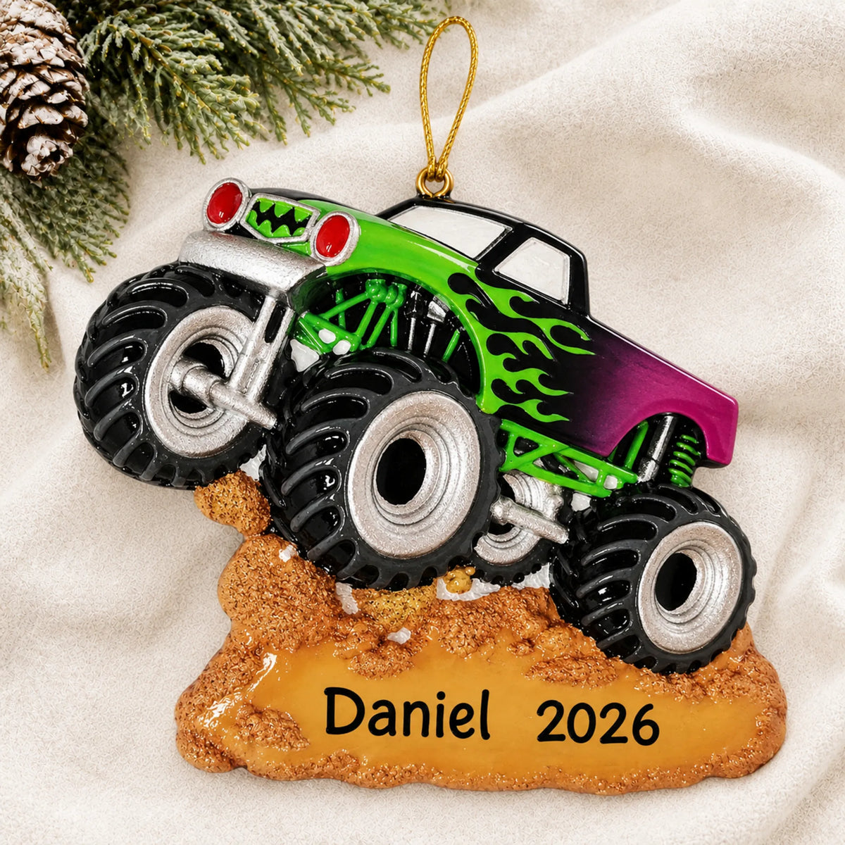 Personalized monster truck christmas ornament laid on a soft white knit blanket