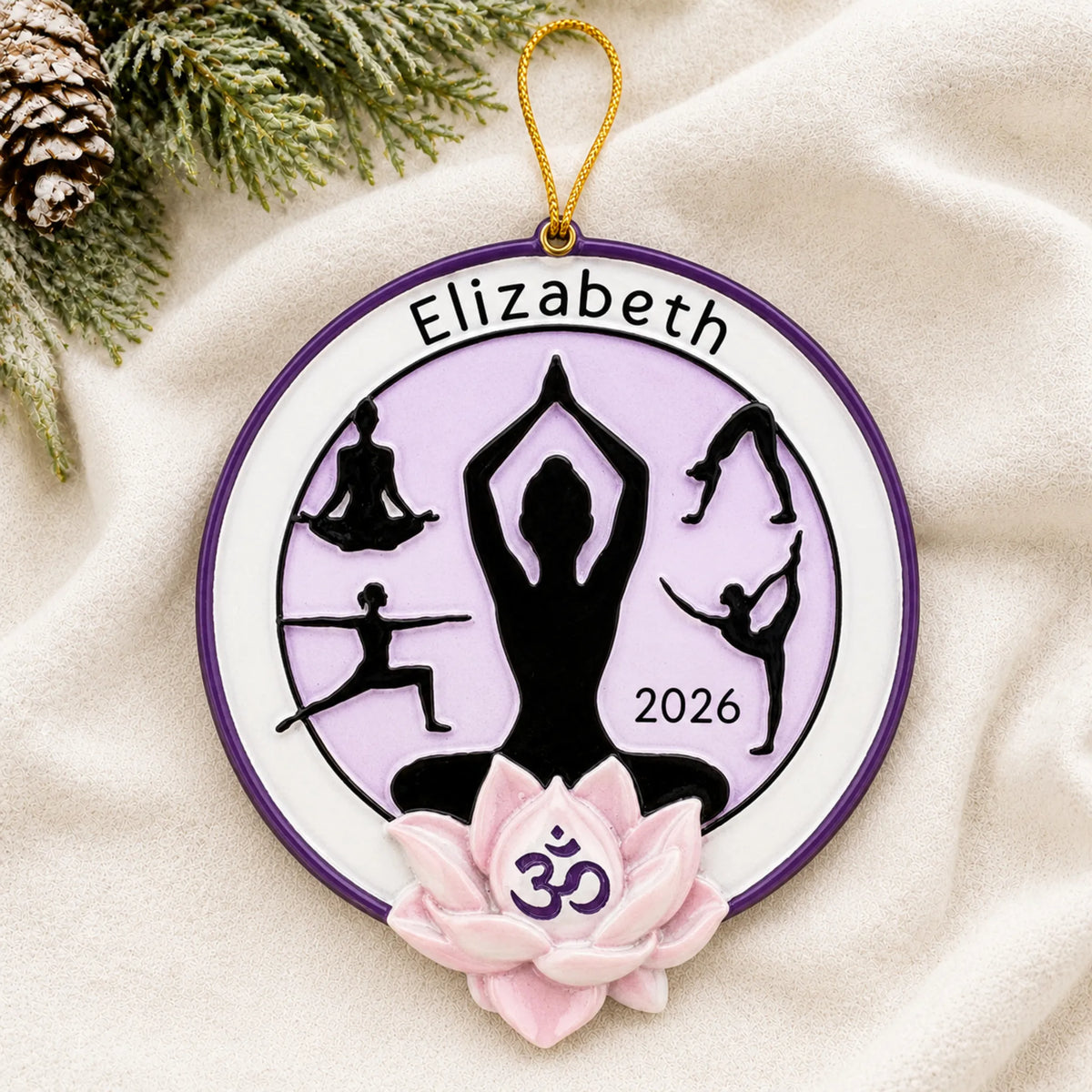 Personalized yoga pose christmas ornament laid on a soft white knit blanket