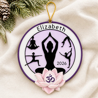 Personalized yoga pose christmas ornament laid on a soft white knit blanket