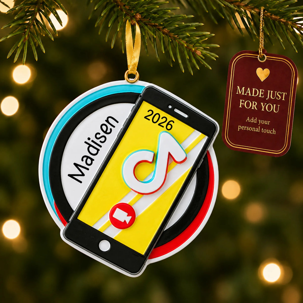 Viral video star christmas ornament hanging on a lit Christmas tree with a Made Just For You gift tag