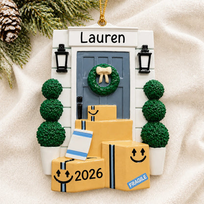 Personalized online shopping delivery christmas ornament laid on a soft white knit blanket