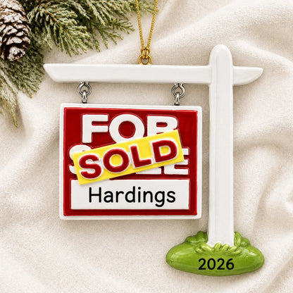 Personalized For Sale Sold New Home christmas ornament laid on a soft white knit blanket