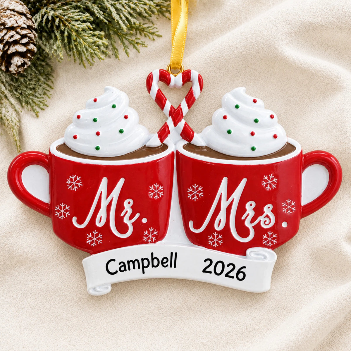 Personalized Mr & Mrs Hot Cocoa christmas ornament laid on a soft white knit blanket