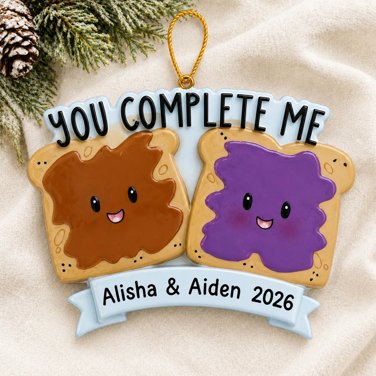 Personalized Peanut Butter & Jelly Couple christmas ornament laid on a soft white knit blanket