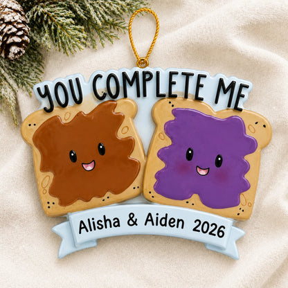 Personalized Peanut Butter & Jelly Couple christmas ornament laid on a soft white knit blanket