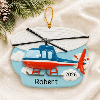 Personalized helicopter christmas ornament laid on a soft white knit blanket